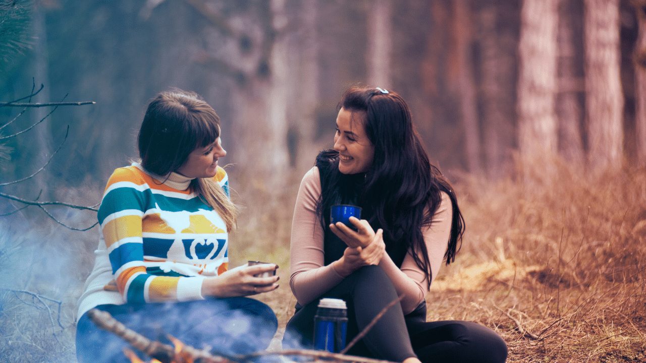 Two friends in warm conversation by a campfire